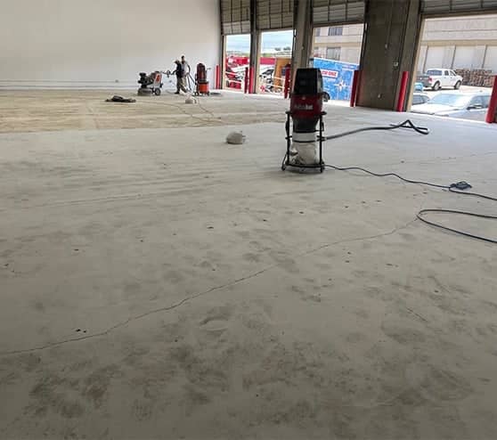 employee smoothing the surface out for new epoxy flooring