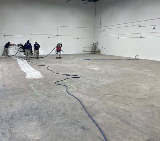 MACH ONE® employees working on new epoxy flooring for LLumar Window and Paint Protection Film