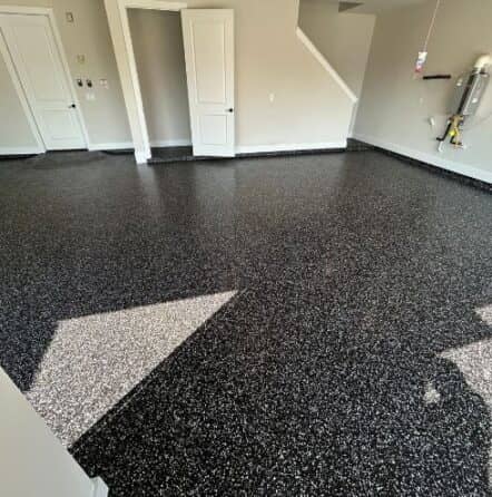 homeowner garage with black and white epoxy flake flooring installed