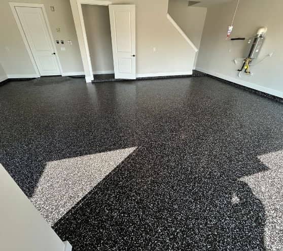 homeowner garage with black and white epoxy flake flooring installed
