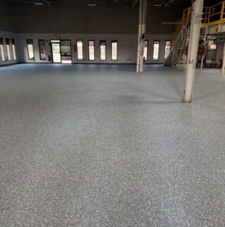 business owner with Blue Epoxy Flake Flooring installed