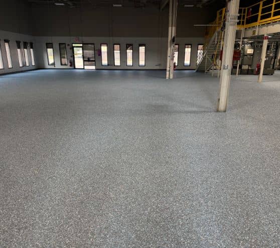business owner with Blue Epoxy Flake Flooring installed