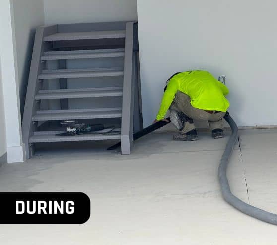 MACH ONE® employee vacuuming homeowner garage before new flooring installed