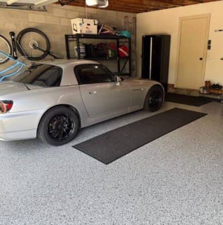 vehicle parked inside homeowner garage on new grey epoxy flake flooring