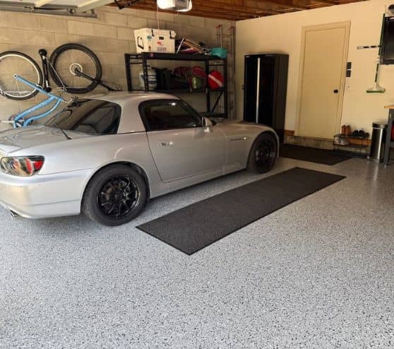 vehicle parked inside homeowner garage on new grey epoxy flake flooring