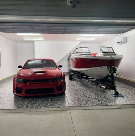 front view of homeowner garage with dodge charger and boat sitting on new epoxy flake flooring