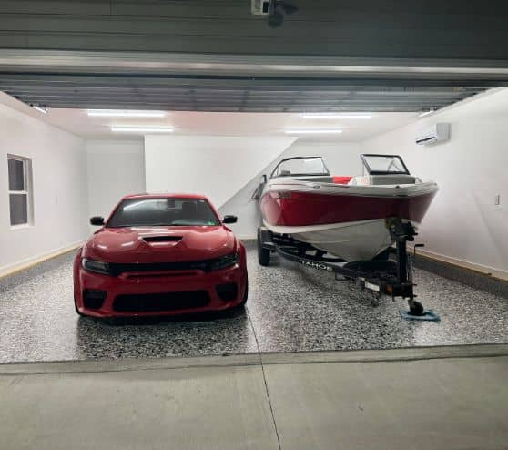 front view of homeowner garage with dodge charger and boat sitting on new epoxy flake flooring