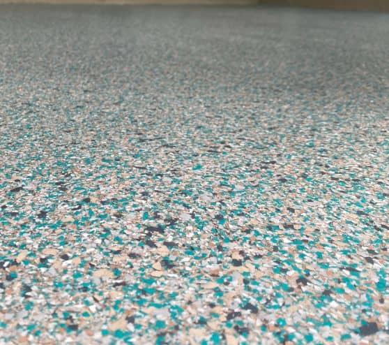 close-up of epoxy flake flooring installation for homeowner patio