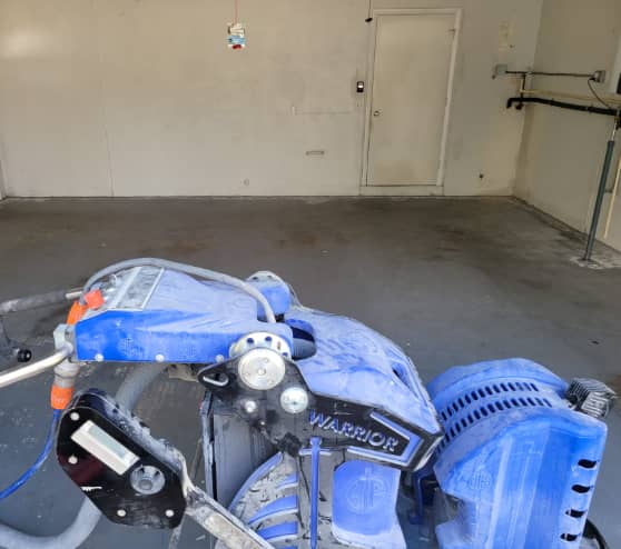 garage floor being prepped for epoxy coating