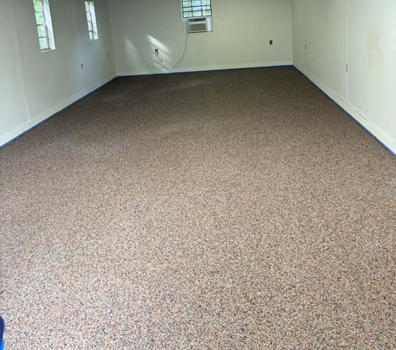 a room with new red epoxy flake flooring