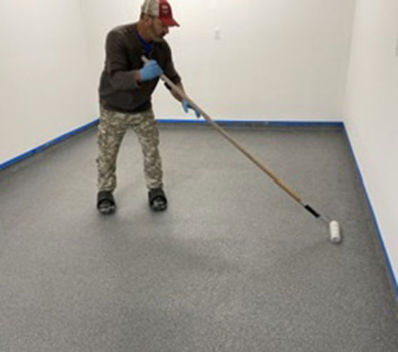 man applying graniflex flooring in condo garage